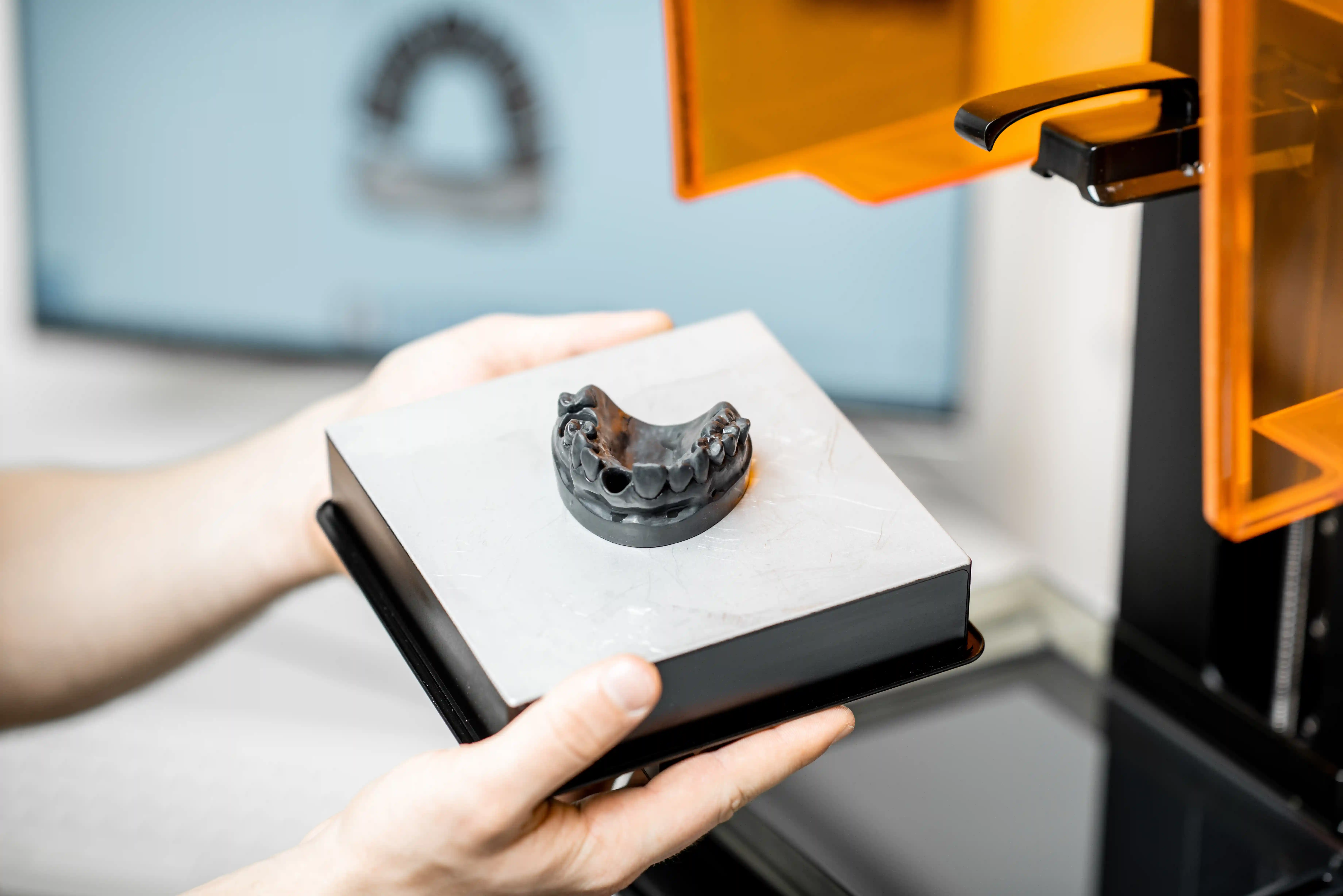 removing a 3d printed dentures from the printer machine